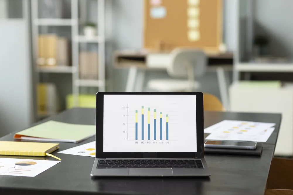 Arbeitsplatz mit Notebook und Balkendiagramm auf dem Bildschirm
