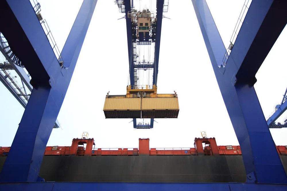 Containerbrücke hebt einen Container gegen den Himmel